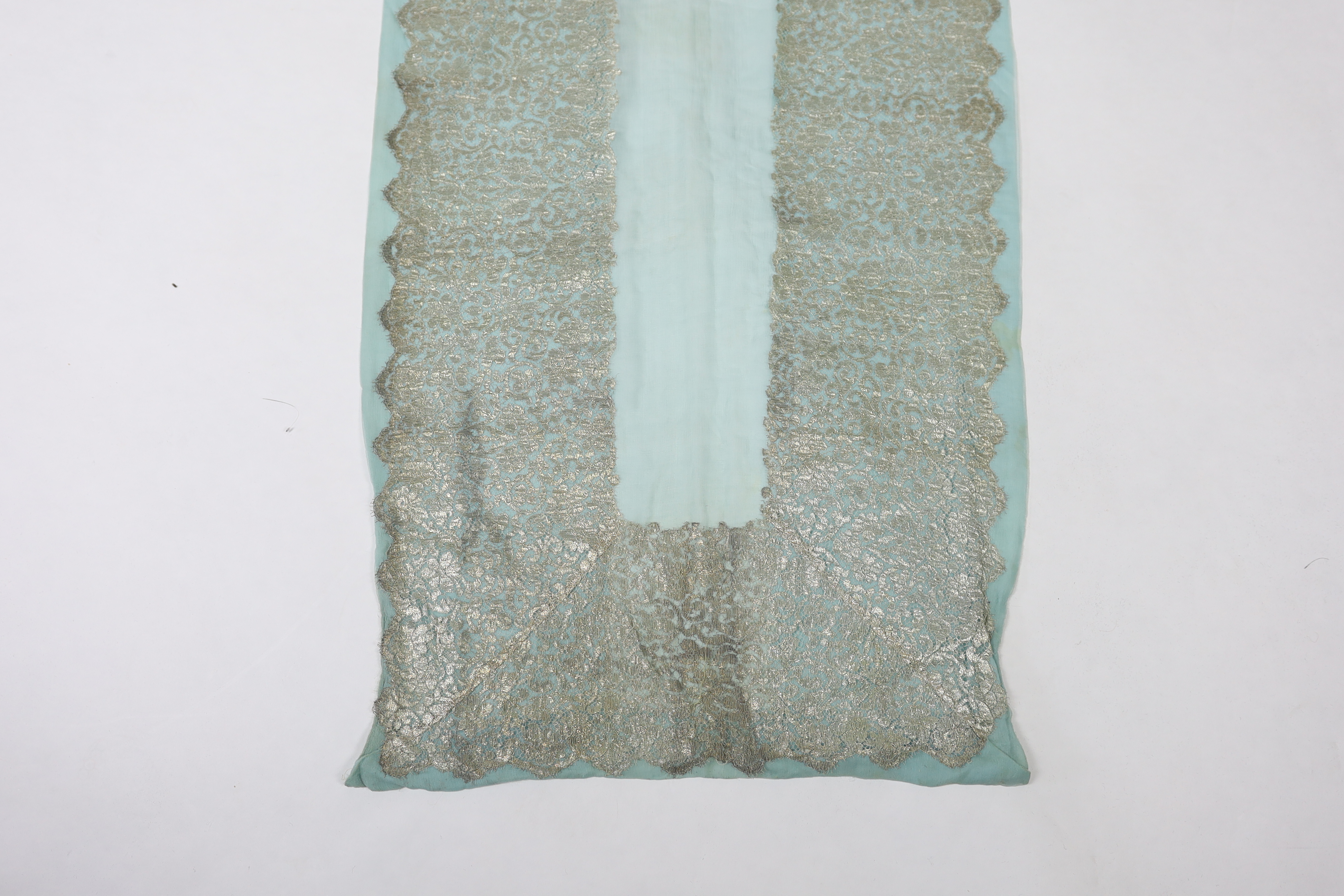 A 1920's silver machine lace and chiffon train, to an evening dress, the silver lace has been cut and appliquéd onto the turquoise chiffon, 209cm long
